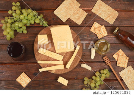Assortment of different varieties of cheese, red wine, grapes and cracker, the basis of the French diet, healthy and natural food selection, advertising card or invitation to a cafe, shop, menu, Assortment of different varieties of cheese, red wine, grapes and cracker, the basis of the French diet, healthy and natural food selection, advertising card or invitation to a cafe, shop, menu, 125631853