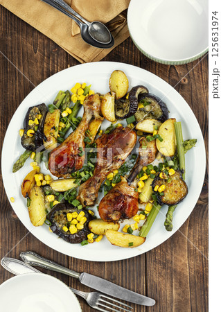 Roast chicken thigh garnished with vegetables. Roast chicken thigh garnished with vegetables. 125631974