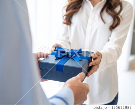 男性へプレゼントを渡す女性 125631985