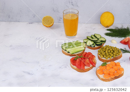 Fried bread, carrots, and cucumbers, tomatoes and peas with lemon juice, green sandwiches, the concept of a healthy diet and weight loss, healthy diet foods on a light background, I love my body. 125632042