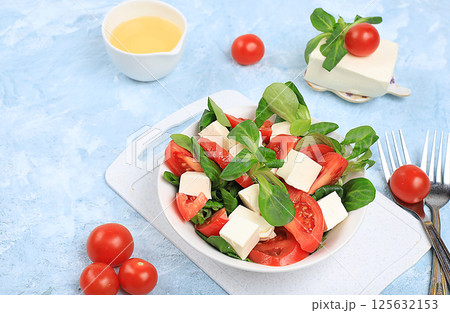 Caprese with mozzarella cheese, cherry tomatoes and fresh arugula, Useful natural breakfast with lemon, detox diet.Traditional Italian food,, cholesterol-free and GMO-free, selective focus, place for Caprese with mozzarella cheese, cherry tomatoes and fresh arugula, Useful natural breakfast with lemon, detox diet.Traditional Italian food,, cholesterol-free and GMO-free, selective focus, place for 125632153