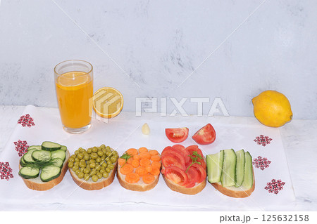 Fried bread, carrots, and cucumbers, tomatoes and peas with lemon juice, green sandwiches, the concept of a healthy diet and weight loss, healthy diet foods on a light background, I love my body. 125632158