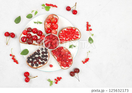 Diet fruit mini sandwiches with soft cottage cheese and fresh berries, raspberries, currants and cherries, a healthy breakfast with ingredients. The concept of healthy and natural food, lifestyle, Diet fruit mini sandwiches with soft cottage cheese and fresh berries, raspberries, currants and cherries, a healthy breakfast with ingredients. The concept of healthy and natural food, lifestyle, 125632173