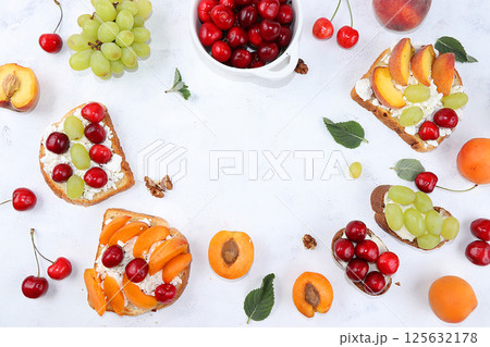 Diet fruit bruschetta with cottage cheese, peaches, grapes and cherries, a healthy breakfast with ingredients. The concept of healthy and natural food, lifestyle, flat lay, place for text Diet fruit bruschetta with cottage cheese, peaches, grapes and cherries, a healthy breakfast with ingredients. The concept of healthy and natural food, lifestyle, flat lay, place for text 125632178