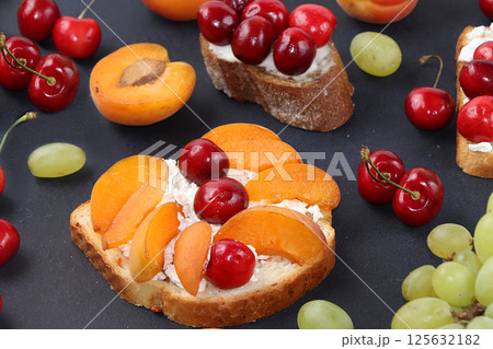 Diet fruit toasts with cottage cheese, peaches, grapes and cherries, healthy breakfast with ingredients. The concept of healthy and natural food, lifestyle, flat lay, place for text 125632182