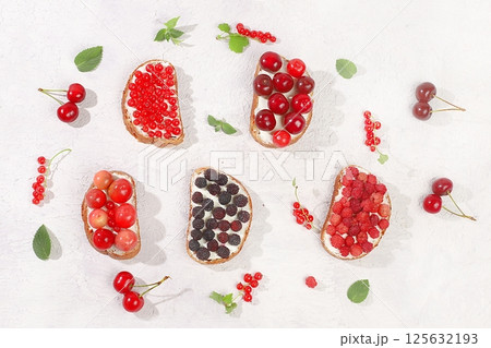 Healthy breakfast with ingredients. Diet fruit mini sandwiches with soft cottage cheese and fresh berries, raspberries, currants and cherries, The concept of healthy and natural food, lifestyle, flat Healthy breakfast with ingredients. Diet fruit mini sandwiches with soft cottage cheese and fresh berries, raspberries, currants and cherries, The concept of healthy and natural food, lifestyle, flat 125632193