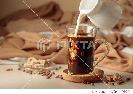 Pouring cream in black coffee. 125632404
