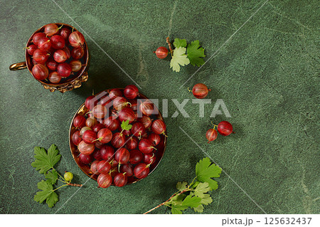 Summer fresh gooseberries on marble green background with leaves, banner for shops, rustic harvest, healthy natural food concept, breakfast with ingredients, cafe business card, selective focus Summer fresh gooseberries on marble green background with leaves, banner for shops, rustic harvest, healthy natural food concept, breakfast with ingredients, cafe business card, selective focus 125632437
