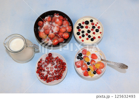 Strawberry yogurt, milk and ripe berries of currants and strawberries on a light background. Delicious healthy breakfast of yogurt and strawberries with copy space, top view, selective focus 125632493