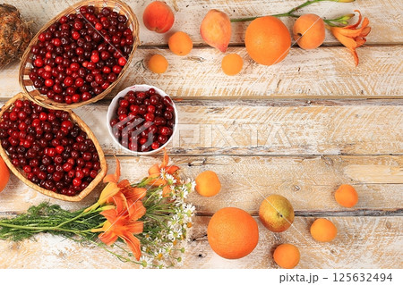 Summer berries and fruits on a wooden background with lilies and daisies, harvesting in the village, healthy natural food concept, breakfast with ingredients, store advertisement, business card for 125632494