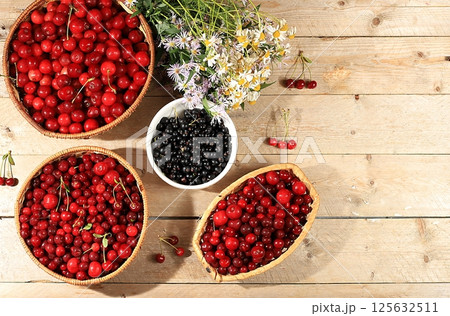 Summer cherry berries in baskets on a wooden background with daisies,wild flowers, harvesting in the village, the concept of healthy natural food, breakfast with ingredients, shop advertising, cafe Summer cherry berries in baskets on a wooden background with daisies,wild flowers, harvesting in the village, the concept of healthy natural food, breakfast with ingredients, shop advertising, cafe 125632511