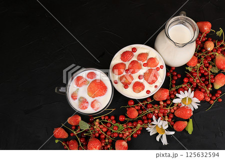 Strawberry yogurt, milk and ripe currant berries and strawberries on a black background. Delicious healthy breakfast of yogurt and strawberries with copy space, top view, selective focus Strawberry yogurt, milk and ripe currant berries and strawberries on a black background. Delicious healthy breakfast of yogurt and strawberries with copy space, top view, selective focus 125632594