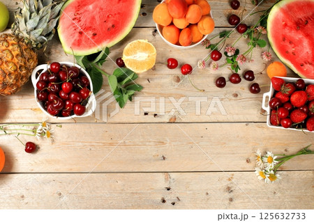 Summer berries and fruits on wooden background, healthy natural food concept, breakfast with ingredients, top view, advertisement for a store, business card for a cafe, invitation with place for text, 125632733