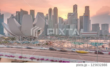Aerial view of sunset over Helix Bridge and Bayfront Avenue with traffic timelapse at Marina Bay, Singapore 125632866