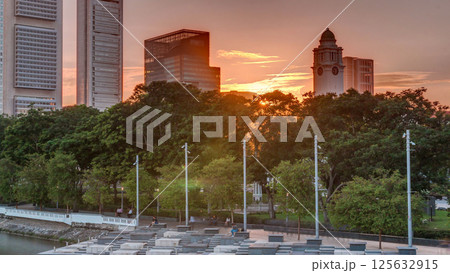 Sunset over Singapore skyscrapers skyline with white Anderson Bridge near esplanade park timelapse. 125632915