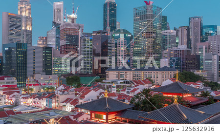 The Buddha Tooth Relic Temple comes alive at night in Singapore Chinatown day to night timelapse, with the city skyline in the background. The Buddha Tooth Relic Temple comes alive at night in Singapore Chinatown day to night timelapse, with the city skyline in the background. 125632916