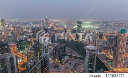 Panoramic aerial view of business bay towers in Dubai day to night timelapse. 125632971