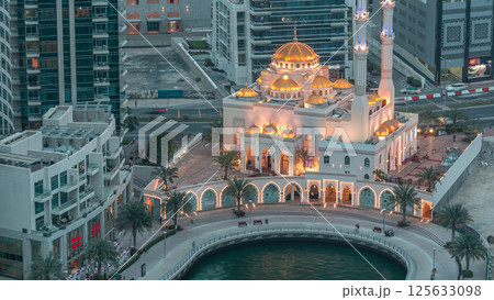 Modern residential architecture of Dubai Marina and Mohammed Bin Ahmed Almulla Mosque aerial day to night timelapse 125633098