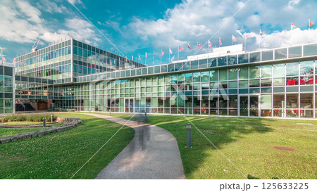 Modern low rise glass office building in business district and green lawn in inner yard timelapse hyperlapse 125633225