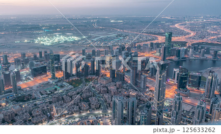 Downtown of Dubai night to day timelapse before sunrise. Aerial view with towers and skyscrapers Downtown of Dubai night to day timelapse before sunrise. Aerial view with towers and skyscrapers 125633262