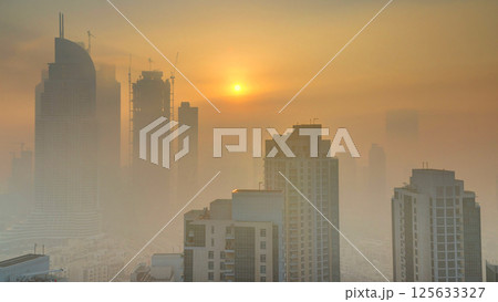 Foggy morning sunrise in downtown of Dubai timelapse. 125633327