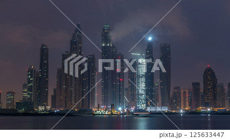 Panorama of modern skyscrapers in Dubai city night to day timelapse from the Palm Jumeirah Island. 125633447