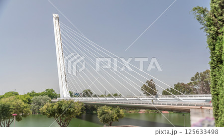 Alamillo Bridge with tall pylon and steel cables crossing over Guadalquivir River timelapse hyperlapse in Seville, Spain 125633498