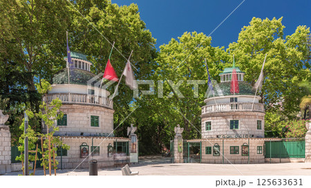 Timelapse hyperlapse of Lisbon Zoo entrance with open gates and flags on towers during summer. Lisbon, Portugal Timelapse hyperlapse of Lisbon Zoo entrance with open gates and flags on towers during summer. Lisbon, Portugal 125633631