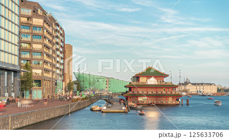 Hyperlapse of pagoda on the water, set against the backdrop of historical city center architecture at sunset timelapse. Amsterdam, Netherlands 125633706