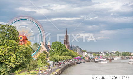 Aerial hyperlapse of pleasure boats on the Rhine Main, framed by the spire of Kaiserdom St. Bartholomaus. Germany 125633778