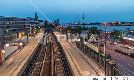 Aerial day to night timelapse of trains arriving at Landungsbrucken station in Hamburg, Germany. Aerial day to night timelapse of trains arriving at Landungsbrucken station in Hamburg, Germany. 125633796