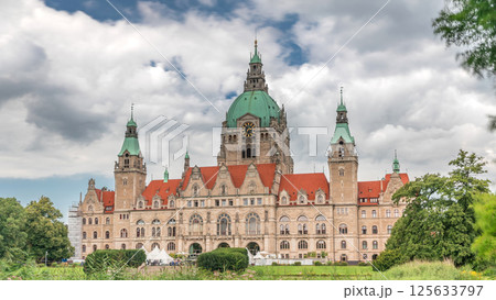 Hyperlapse of Hanover's New Town Hall, a landmark castle-like structure surrounded by park and lake under a cloudy sky. Germany 125633797