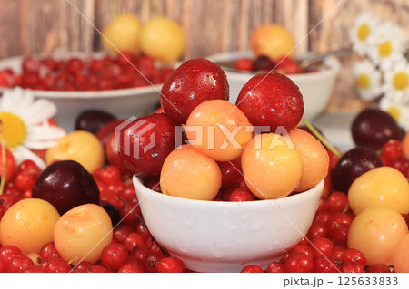 Fresh berries of sweet cherry and cherry with droplets, Cherry and sweet cherry on a wooden light background, selective focus. Natural nutrition. Fresh berries of sweet cherry and cherry with droplets, Cherry and sweet cherry on a wooden light background, selective focus. Natural nutrition. 125633833
