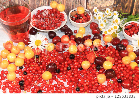 Fresh berries of red currant, cherries and cherries, top view,. Red currant and sweet cherry on a wooden light background, selective focus. Natural nutrition 125633835