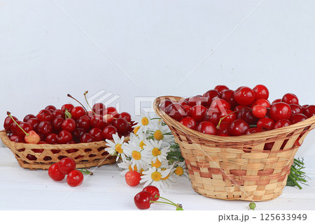 Fresh cherries berries in a basket on a light table, sweet cherries on a wooden light background, selective focus, healthy breakfast, healthy food concept, harvesting 125633949