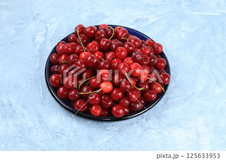 Fresh cherries berries in a basket on a light table, top view, sweet cherry on a wooden light background, selective focus. Healthy breakfast, healthy food concept, harvesting 125633953