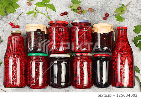 Jars with raspberry, cherry, gooseberry jam and compote on kitchen background with leaves and fresh berries, home canning concept, banner and advertisement of shop and market, village harvest, Jars with raspberry, cherry, gooseberry jam and compote on kitchen background with leaves and fresh berries, home canning concept, banner and advertisement of shop and market, village harvest, 125634002