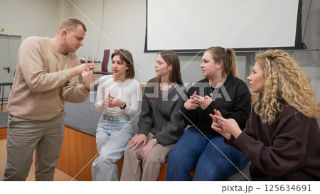 Young people communicate in sign language in a university classroom.  125634691