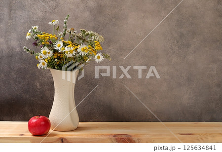 Floral composition of wild herbs and flowers on a wooden table in a rustic style, autumn background, tansy,  125634841