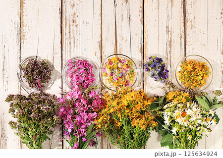 Floral arrangement of wild medicinal herbs and flowers on a wooden table, a bouquet of Hypericum, oregano, fireweed, mint, celandine, chamomile and yarrow, a collection of useful herbs for 125634924