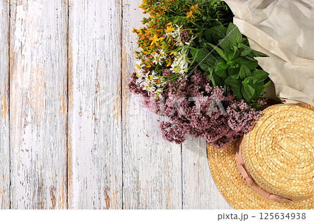 A flower arrangement of wild medicinal herbs on a wooden table in a canvas eco-friendly bag, a bouquet of St. John's wort, oregano, mint, chamomile, a collection of useful herbs . 125634938