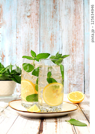 Medicinal herbal tea or peppermint infusion with lemon and ice, concept of detox diet and alternative traditional medicine, collection of useful herbs for treatment according. Medicinal herbal tea or peppermint infusion with lemon and ice, concept of detox diet and alternative traditional medicine, collection of useful herbs for treatment according. 125634946