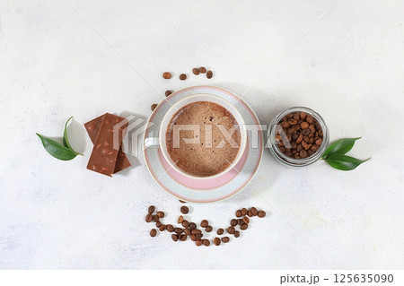 Coffee drink with milk, chocolate and whipped cream, cappuccino coffee, latte, cinnamon, coffee beans on a gray concrete table, modern coffee shop advertisement, selective focus, top view, space for 125635090