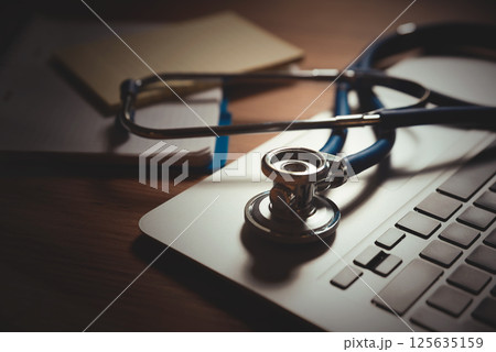 Stethoscope on laptop keyboard, telehealth concept 125635159