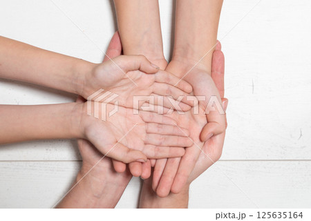 A group of hands are clasped together and unity 125635164
