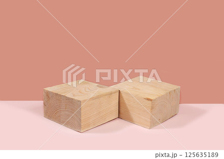 Abstract background with natural wooden podiums and long shadows on a pink wall, an empty showcase for cosmetic products demonstration or presentation, minimal ecology concept, selective focus 125635189