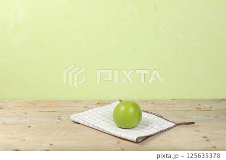 Empty wooden table with green apple on old background with place for text, rustic style, healthy lifestyle and weight loss concept, mock up for design and showcase for product demonstration, selective 125635378