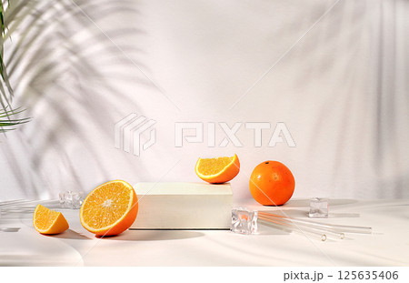 Premium podium with shadows, orange slices and ice cubes on sunny elegant background, summer party concept, minimal abstract background for cosmetics product presentation, design template, podium on 125635406