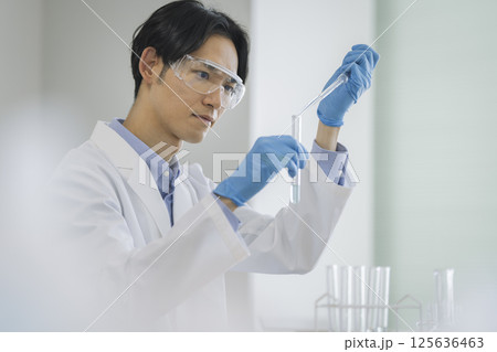試験管を持って作業をする白衣の男性　実験　イメージ 125636463