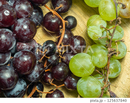 Grapes kishmish on a wooden background. The grapes are overripe. Harvest in the village. Grapes kishmish on a wooden background. The grapes are overripe. Harvest in the village. 125637840